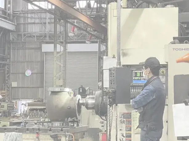 製造機械の前で作業する機械オペレーター